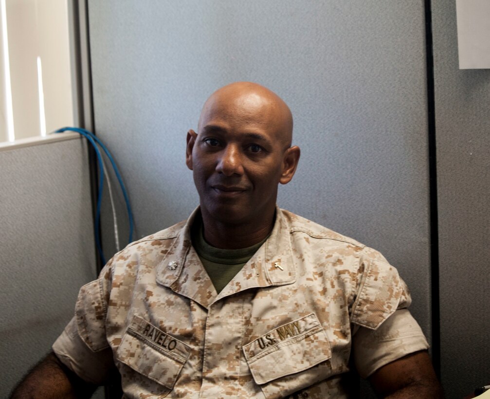 U.S. Navy Cmdr. Samuel Ravelo poses for a photo at his desk aboard Camp Pendleton, Calif., Oct. 28, 2014. Commander Ravelo is the chaplain for the 15th Marine Expeditionary Unit. (U.S. Marine Corps photo by Cpl. Elize McKelvey/Released)