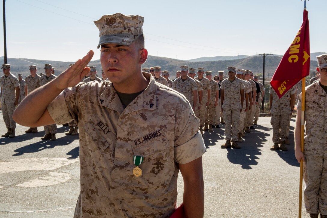 Lance Cpl. Anthony Kelly salutes Lt. Col. Kevin Prindiville after being awarded the Navy and Marine Corps Commendation medal at a formation at the Military Police Department on Oct. 29.
