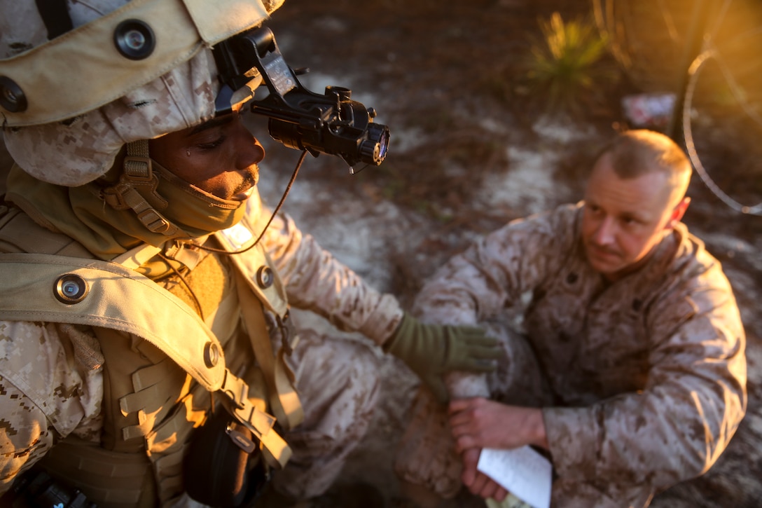 Cpl. Jaquan Derricotte (left), a radio operator with Headquarters Battery, 10th Marine Regiment, 2nd Marine Division, from Athens, Ga., addresses a Marine simulating hysteria as part of a mass casualty training during Exercise Rolling Thunder on Fort Bragg, N.C., Oct. 25, 2014. The training allowed Marines to practice battlefield trauma techniques on their fellow Marines, who simulated lost limbs, blindness, shrapnel wounds, and other battlefield injuries.  (U.S. Marine Corps photo released by Lance Cpl. Kirstin Merrimarahajara/ Released)