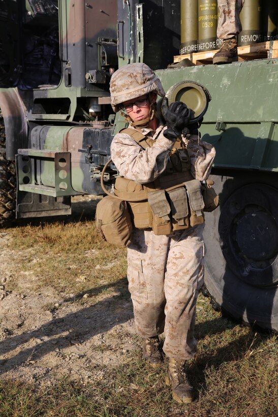 Lance Cpl. Vicki A. Harris, a cannoneer with Battery A, Ground Combat Element Integrated Task Force, carries an M777A2 Lightweight Howitzer round to the Gun 3 ammo pit prior to conducting live-fire artillery missions at Marine Corps Base Camp Lejeune, North Carolina, Oct. 30, 2014. Marines of Battery A conducted a live-fire artillery shoot, Oct. 28-30, 2014. From October 2014 to July 2015, the GCEITF will conduct individual and collective level skills training in designated ground combat arms occupational specialties in order to facilitate the standards based assessment of the physical performance of Marines in a simulated operating environment performing specific ground combat arms tasks. (U.S. Marine Corps photo by Sgt. Alicia R. Leaders/Released)