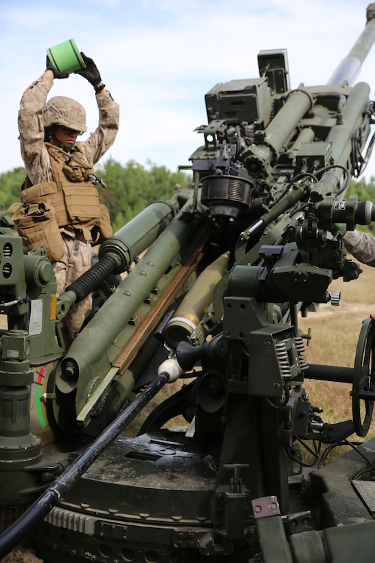Cpl. Tatiana A. Rodriguez, a cannoneer with Battery A, Ground Combat Element Integrated Task Force, waits to place the powder onto the loading tray of the M777A2 Lightweight Howitzer during a fire mission at Marine Corps Base Camp Lejeune, North Carolina, Oct. 29, 2014. Marines of Battery A conducted a live-fire artillery shoot, Oct. 28-30, 2014. From October 2014 to July 2015, the GCEITF will conduct individual and collective level skills training in designated ground combat arms occupational specialties in order to facilitate the standards based assessment of the physical performance of Marines in a simulated operating environment performing specific ground combat arms tasks. (U.S. Marine Corps photo by Sgt. Alicia R. Leaders/Released)
