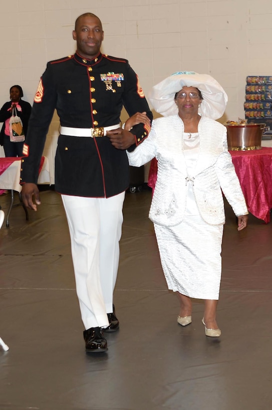 Marines from the installation escort breast cancer survivors down a runway in a hat fashion show at Phoebe HealthWorks, Albany, Ga., Oct. 18. The event was one of several activities conducted during a Women’s Health Conference, which celebrated breast cancer survivors.