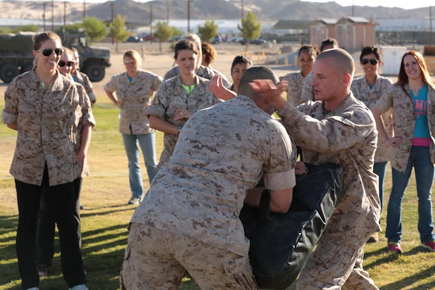 Cpl. Scott Darby, communications, 7th Marine Regiment, demonstrates Marine Corps Martial Arts Program techniques during a Jane Wayne day aboard the Combat Center, Oct. 8, 2014. The spouses received a MCMAP demonstration and were then able to apply the techniques learned. (Photo by Pfc. Medina Ayala-Lo)