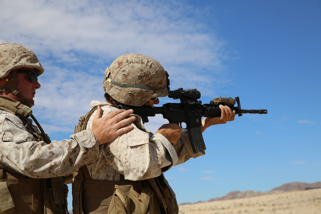 Brandi Long, spouse, receives a demonstration on how to operate the M4 service rifle during a Jane Wayne day for 7th Marine Regiment aboard the Combat Center, Oct. 8, 2014. Spouses were afforded the opportunity to shoot weapons on Range 220. (Photo by Pfc. Medina Ayala-Lo)