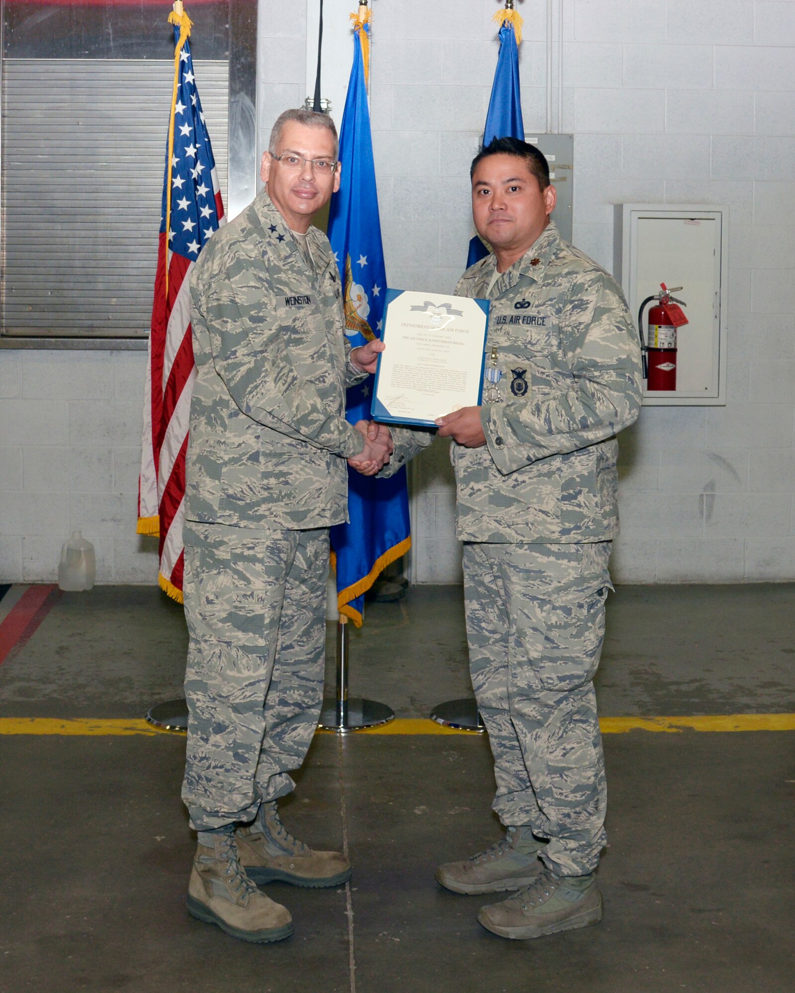 Maj. Gen. Jack Weinstein, Task Force 214 and 20th Air Force commander, presents the Air Force Achievement Medal to Maj. Marcanthony Ortiz, 790th Missile Security Forces Squadron, Oct. 28, 2014, on F.E. Warren Air Force Base, Wyo. The AFAM was awarded to Ortiz for his role in implementing a newly created flight commander's course. (U.S. Air Force photo by Lan Kim)
