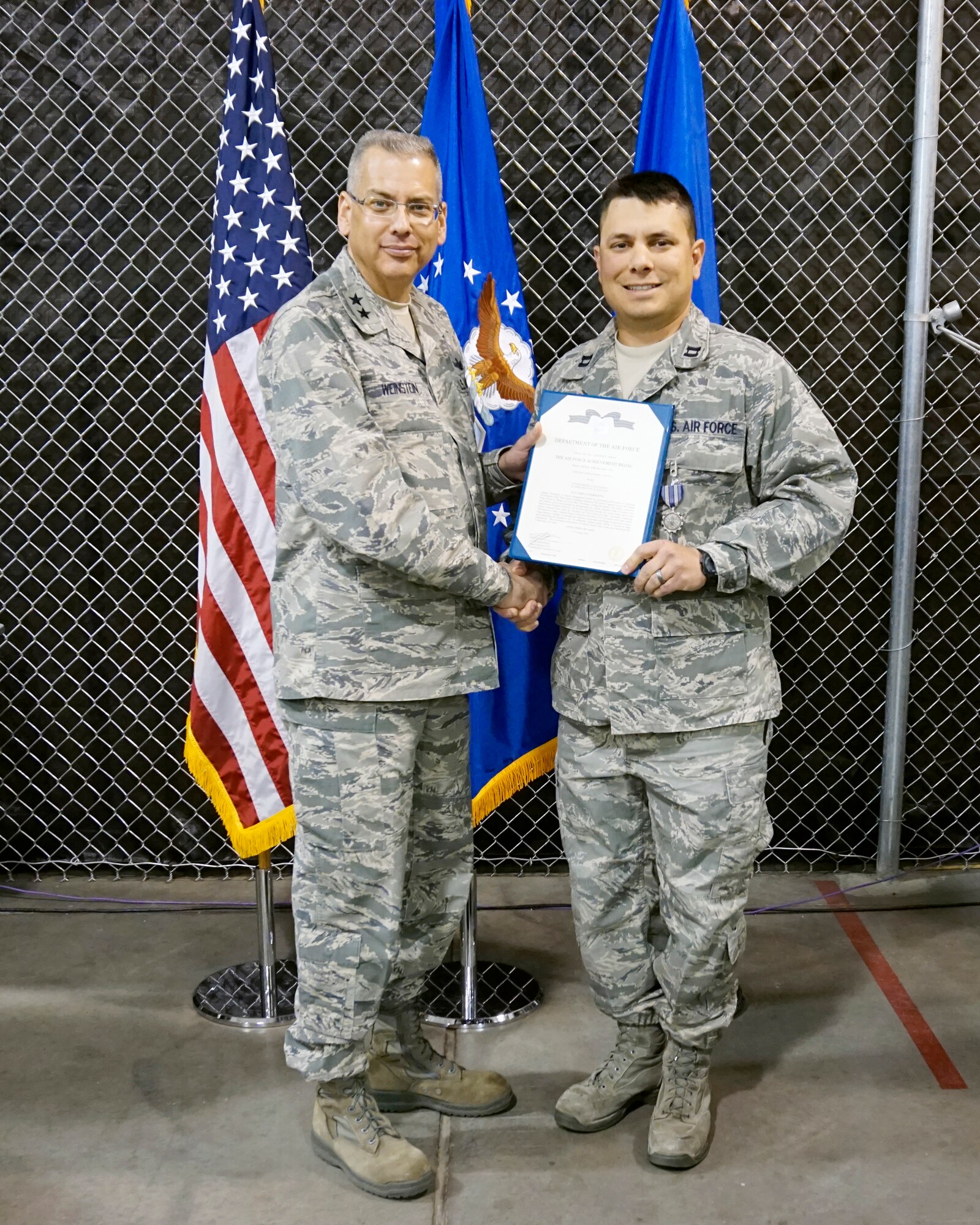 Maj. Gen. Jack Weinstein,  Task Force 214 and 20th Air Force commander, presents the Air Force Achievement Medal to Capt. Christopher Dupuis, 90th Logistics Readiness Squadron Oct. 27, 2014, on F.E. Warren Air Force Base, Wyo. The AFAM was awarded to Dupuis for his role in implementing a newly created a flight commander's course. (U.S. Air Force photo by Lan Kim)
