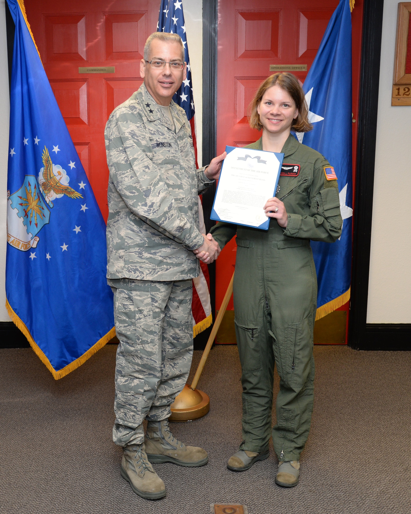 Maj. Gen. Jack Weinstein,  Task Force 214 and 20th Air Force commander, presents the Air Force Achievement Medal to Capt. Amanda Filiowich, 320th Missile Squadron Oct. 27, 2014, on F.E. Warren Air Force Base, Wyo. The AFAM was awarded to Filiowich for her role in implementing a newly created  flight commander's course. (U.S. Air Force photo by Lan Kim)