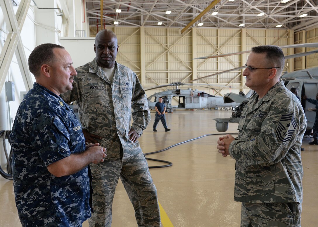 U.S. Navy Master Chief Petty Officer Theron Fischer, Helicopter Sea Combat Squadron Two Five command chief, briefs Chief Master Sgt. Harold Hutchison, Pacific Air Forces command chief master sergeant, and Chief Master Sgt. Jerry Moore, 11th Air Force command chief master sergeant, on the support HSC-25 provides for the base Oct. 21, 2014, on Andersen Air Force Base, Guam. Hutchison visited the base to observe first-hand mission operations and to speak with Airmen and address their concerns. (U.S. Air Force photo by Senior Airman Katrina M. Brisbin/Released)