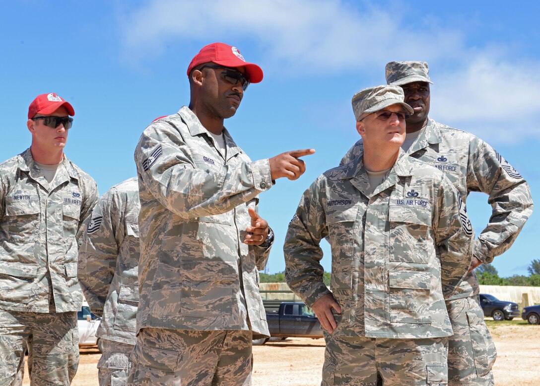 Staff Sgt. Will Greer, 554th RED HORSE squadron structural craftsman, and Chief Master Sgt. Harold Hutchison, Pacific Air Forces command chief, discuss the processes of an Airman led construction project with Oct. 20, 2014, at Andersen Air Force Base, Guam. Hutchison visited the base to observe first-hand mission operations and to speak with Airmen and address their concerns. (U.S. Air Force photo by Senior Airman Katrina M. Brisbin/Released)