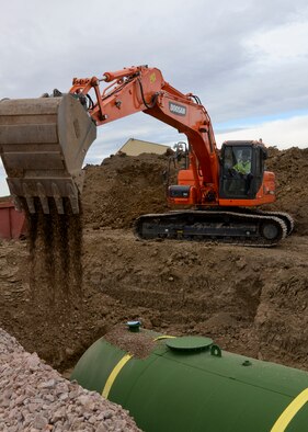 Civilian construction workers install one of two 10,000-gallon fuel containment tanks at Ellsworth Air Force Base, S.D., Oct. 27, 2014. Slated to be completed in November, the new product recovery tanks will collect any fuel spills during fueling operations. These tanks allow fuels management personnel to recover fuel in the event of an emergency spill. In addition to the tanks being installed, 71 cubic yards of the containment system will be repaired. The $2 million-project will protect the environment for Ellsworth AFB. (U.S. Air Force photo by Senior Airman Anania Tekurio/Released)