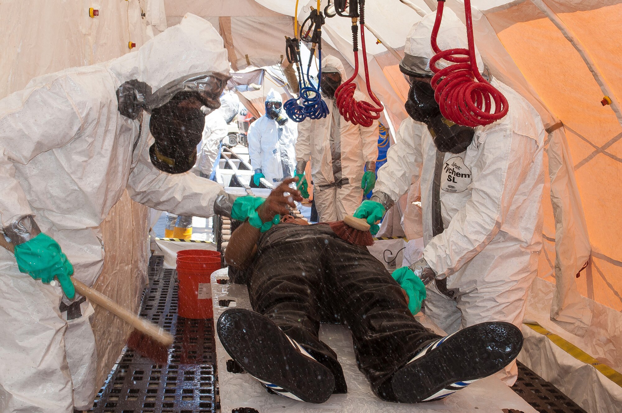 Chemical Support Unit members decontaminate a mock victim during a training exercise observed by Maj. Gen. H. Michael Edwards, the Adjutant General of Colorado, and other Colorado National Guard senior leaders and facilitated by the CONG Chemical, Biological, Radiological, and Nuclear (CBRN) Enhanced Response Force Package (CERFP) team at Maffaq Armor Base, Jordan, May 12, 2014. (Air National Guard photo by Capt. Darin Overstreet)