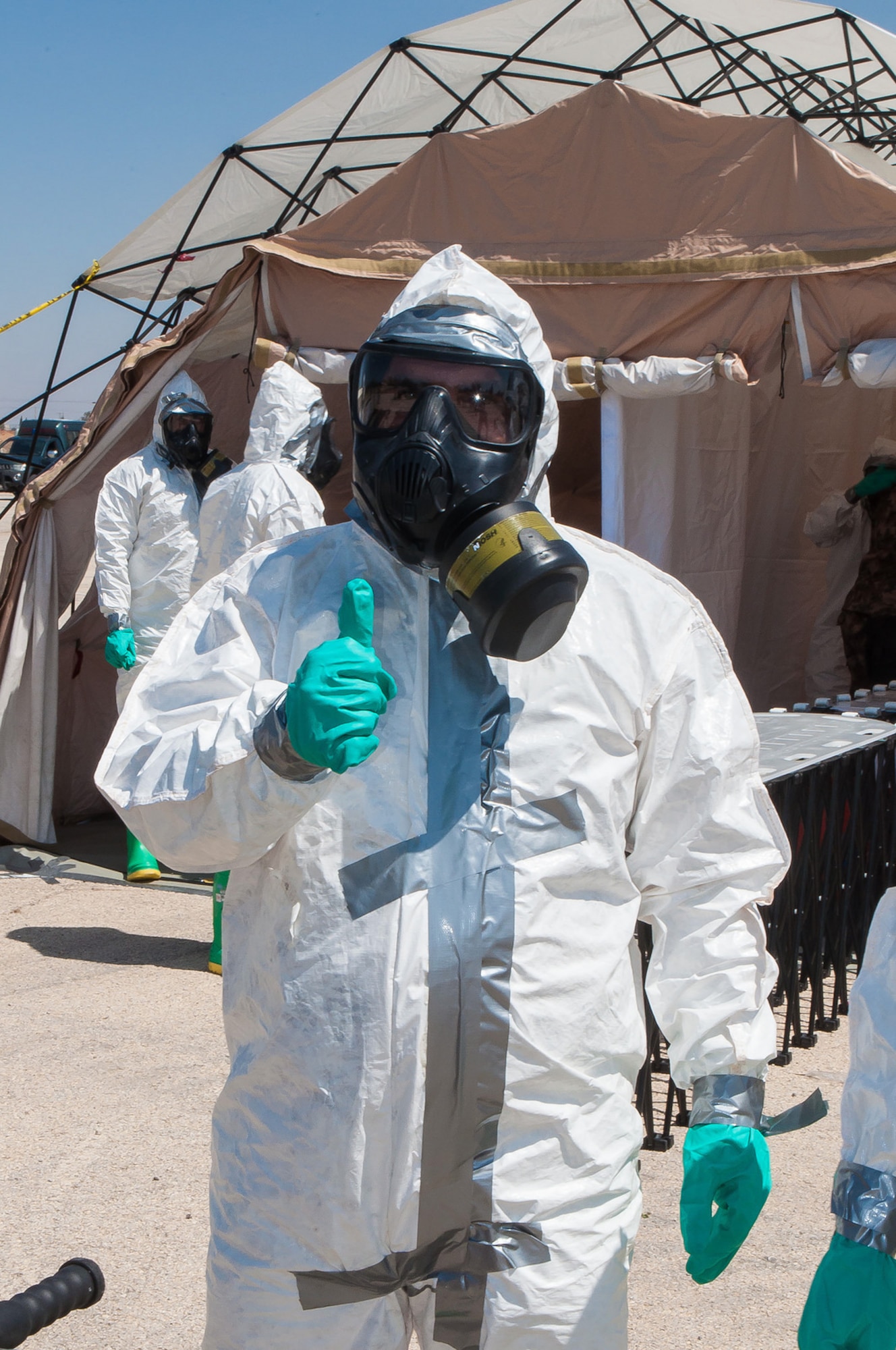 A Jordanian Armed Forces member of the Chemical Support Unit indicates that everything’s a-okay, during a visit from Maj. Gen. H. Michael Edwards, the Adjutant General of Colorado, and other Colorado National Guard senior leaders who came to observe a training exercise facilitated by the CONG Chemical, Biological, Radiological, and Nuclear (CBRN) Enhanced Response Force Package (CERFP) team at Maffaq Armor Base, Jordan, May 12, 2014. (Air National Guard photo by Capt. Darin Overstreet)