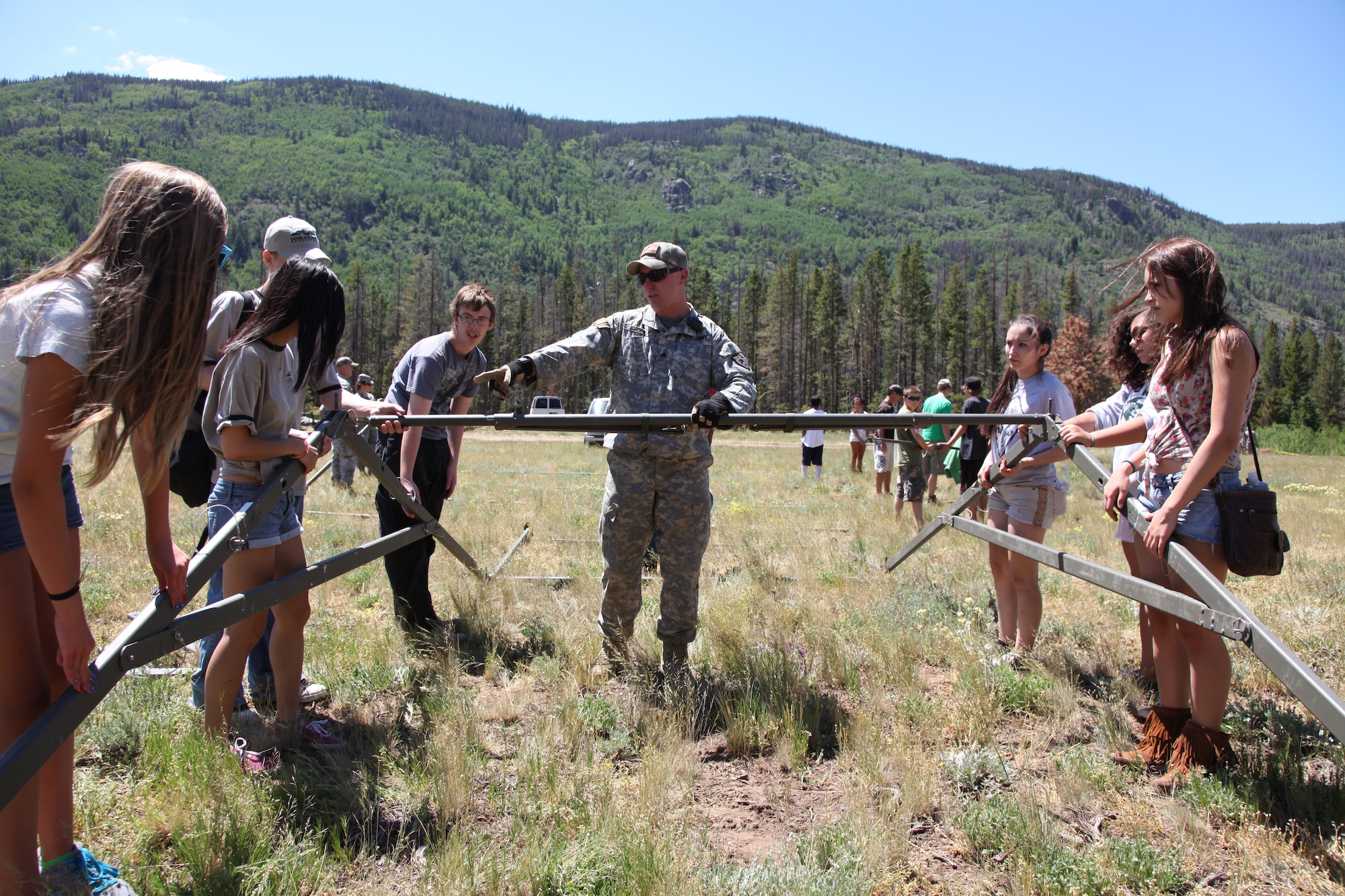 SGT Samuel Groff, Colorado Army National Guard, leads a team of teenagers in building a tent during the week-long Laramie River Valley Rendezvous program near Ft. Collins, Colo. July 6-12. The kids, who are identified as being high-risk for potential drug use, participate in various games and activities throughout the week and are mentored by members of the Colorado National Guard. (U.S. Air National Guard Photo by Tech. Sgt. B. Kevin Coulter) 