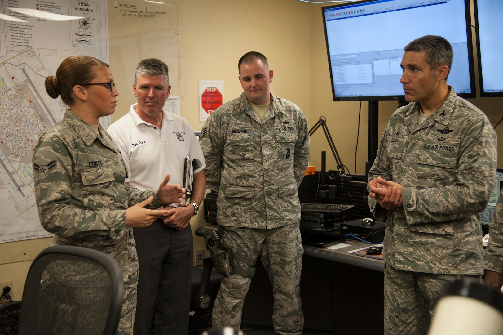Col. Matthew Isler (right), 12th Flying Training Wing commander, and Robert West (second from left), 12th FTW director of maintenance, speak to Airman 1st Class Victoria Conte and Staff Sgt. Samuel Beavers, 902nd Security Forces Squadron Base Defense Operations Center controllers, Oct. 20 at the Joint Base San Antonio-Randolph BDOC. Members of the 12th FTW took part in a 502nd Security Forces Logistics Support Group immersion tour to gain a better understanding of the mission and capabilities of the 502nd SFLSG. (U.S. Air Force photo by Airman 1st Class Stormy Archer)