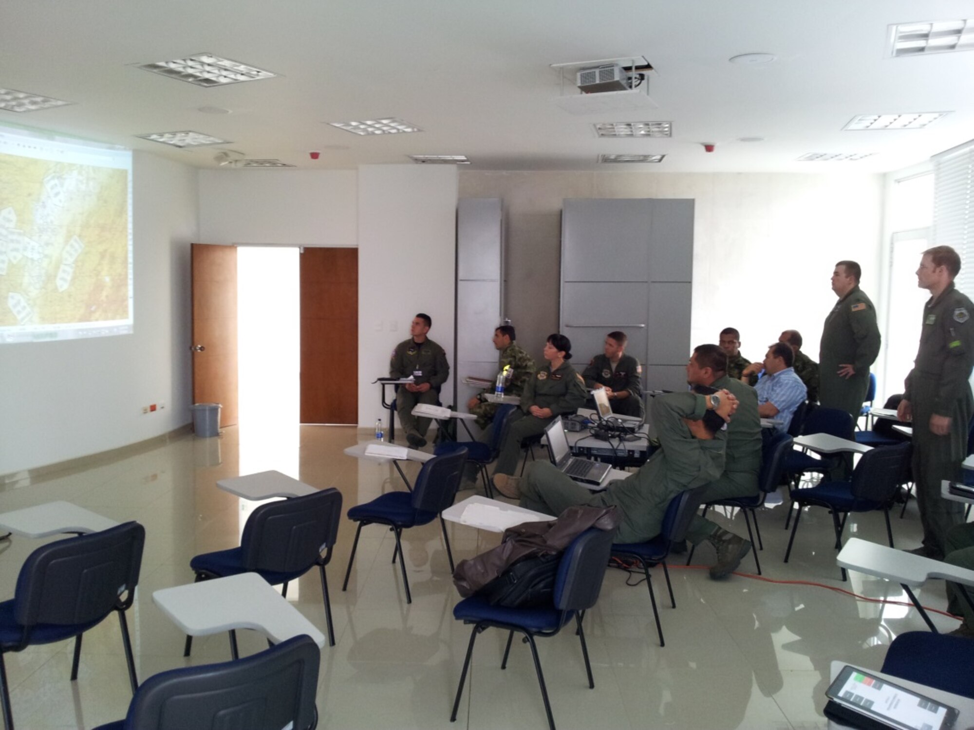 Capt. Benjamin Bull, 123rd Air Wing with the Kentucky Air National Guard, and Maj. Adam Shockley, 61st Airlift Squadron, Little Rock Air Force Base, Ark. lead students through a multi-day Colombian air force mission-planning exercise. (Courtesy photo)