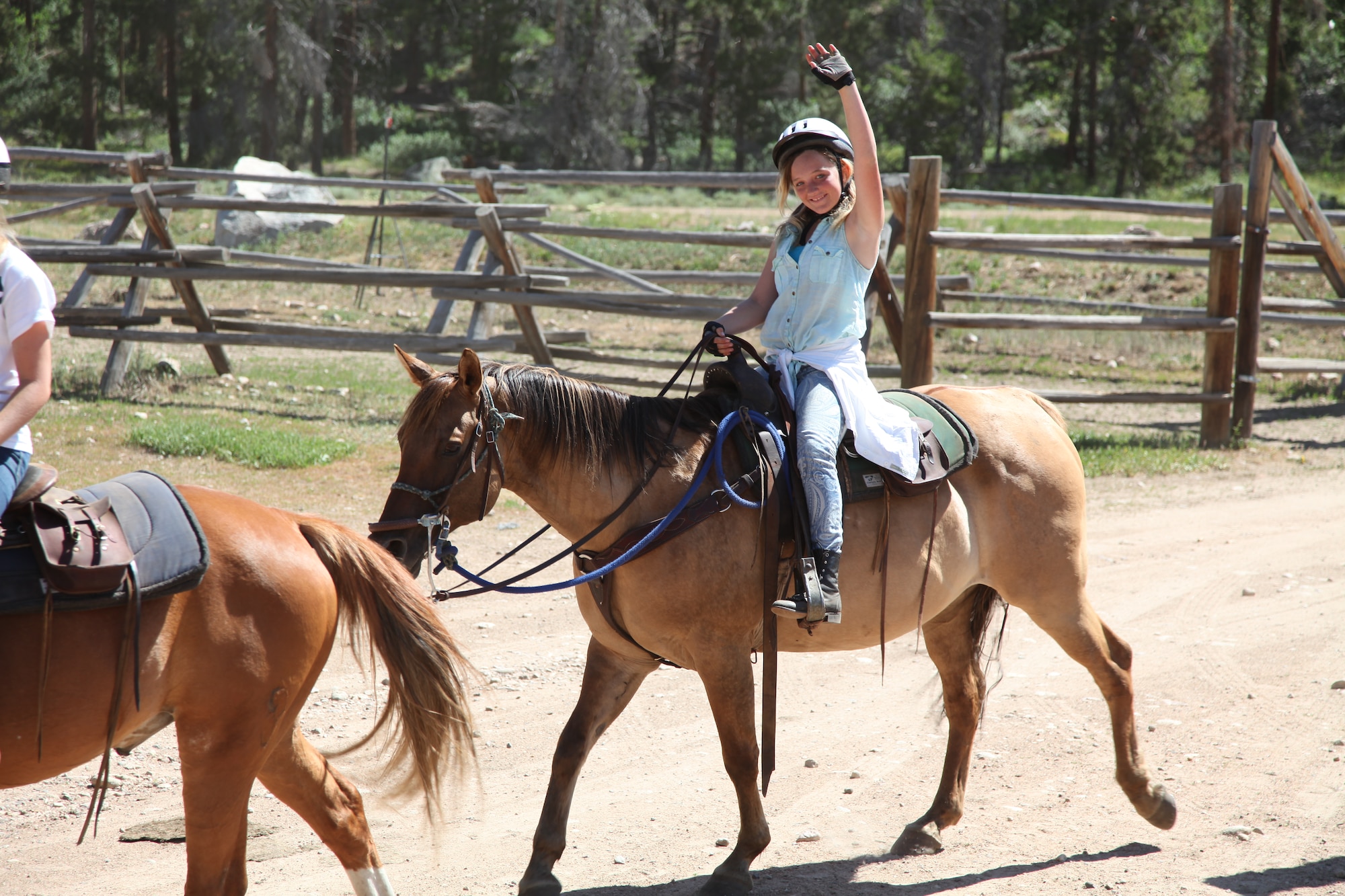 A teenage girl waves as she rides a horse during the week-long Laramie River Valley Rendezvous program near Ft. Collins, Colo. The kids, who are identified as being high-risk for potential drug use, participate in various games and activities throughout the week and are mentored by members of the Colorado National Guard. (U.S. Air National Guard Photo by Tech. Sgt. B. Kevin Coulter) 