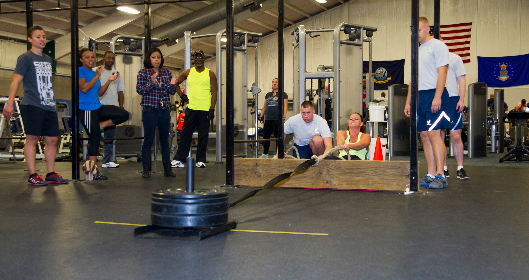 Competitors and spectators watch and cheer on Staff Sgt. Lynn Handle during the 2nd Annual Premier Strongman Challenge at the West Fitness Center on Joint Base Andrews, Md., Oct. 28, 2014. Handle, a 1st Airlift Squadron flight attendant, pulled 135 pounds a distance of 75 feet during the sled pull event. (U.S. Air Force photo/Airman 1st Class Ryan J. Sonnier) 
