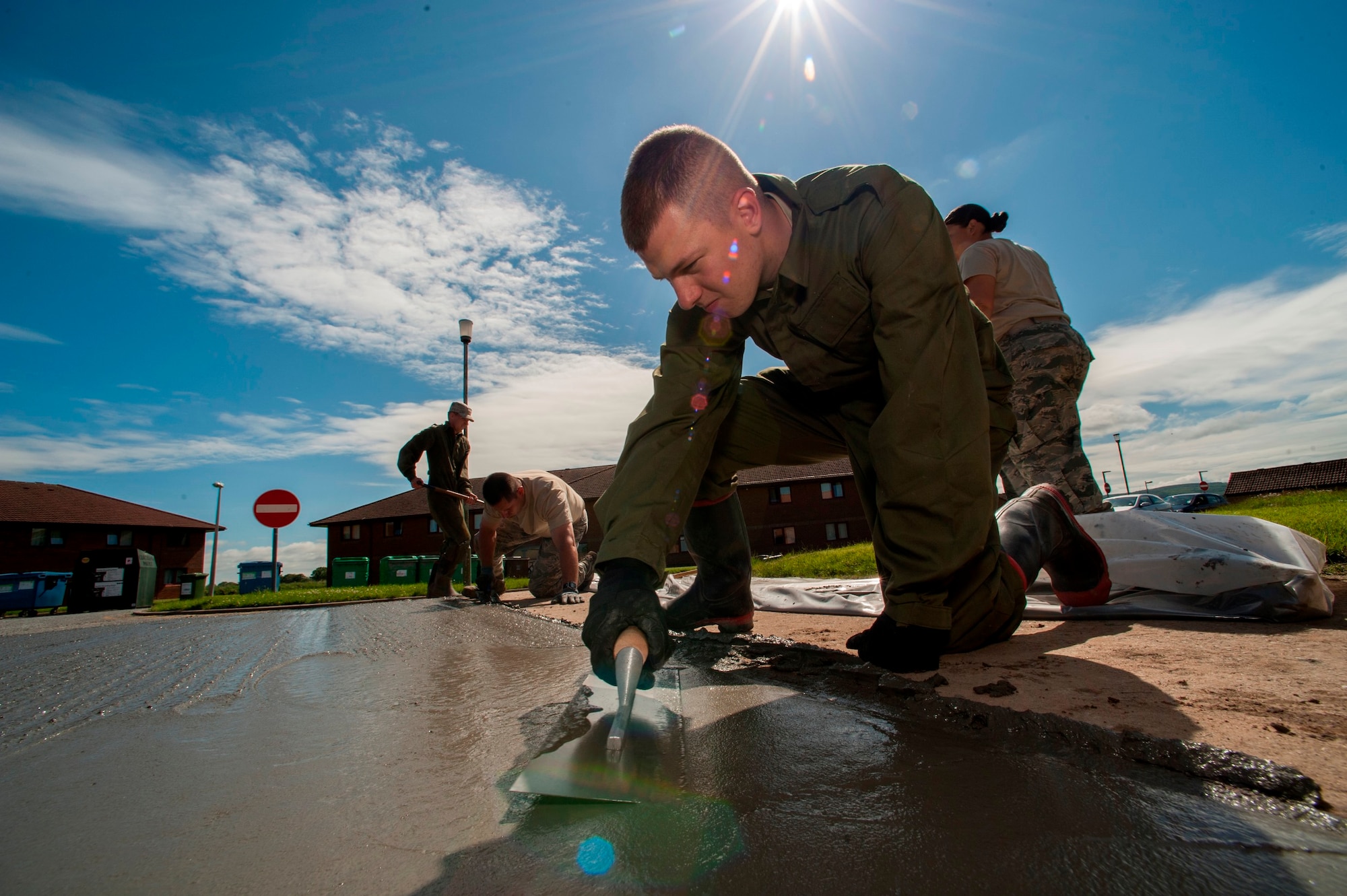 U.S. Air Force  Senior Airman Alexander Root-Davis, 140th Civil Engineer Squadron, Colorado Air National Guard, uses a finishing trowel to smooth out the top of freshly laid cement that will help improve the base junior dorms area once completed, during a deployed for training trip, known as Exercise Flying Rose at Kinloss Barrack in Forres, Moray, Scotland, United Kingdom, Jun. 16, 2014. Over 40 members of the 140th CES are in Scotland for their annual training and are accomplishing five construction projects that will improve several areas around Kinloss Barracks, during Exercise Flying Rose hosted by the British Army before returning back to Colorado later this month. (U.S. Air National Guard photo by Tech. Sgt. Wolfram M. Stumpf)