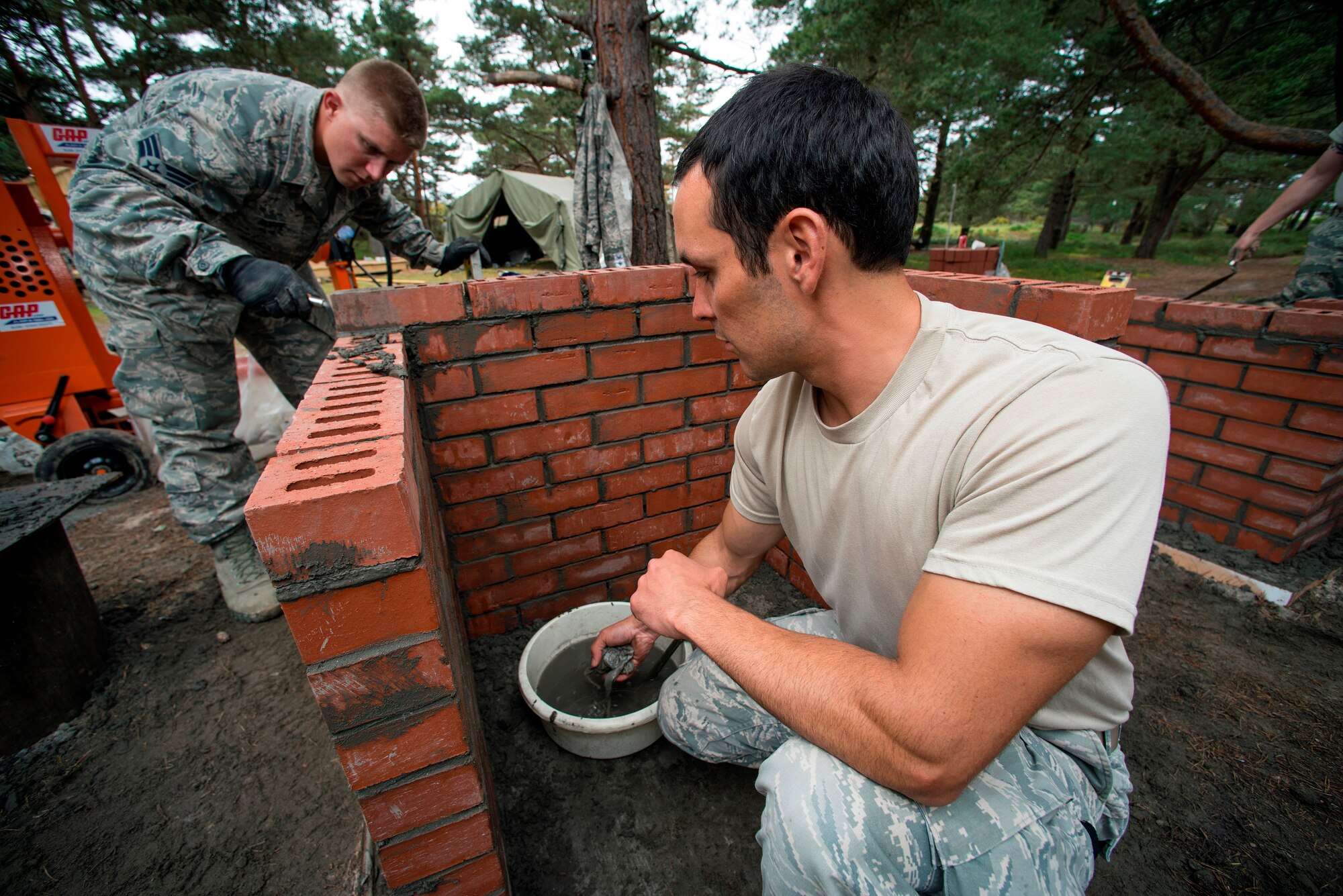 U.S. Air Force Senior Airman Justin Hoppe (left) and Staff Sgt. Tyson Bladassare, 140th Civil Engineer Squadron, Colorado Air National Guard, work on laying bricks on a new Barbecue Grill at a camp area, during a deployed for training trip, known as Exercise Flying Rose at Kinloss Barrack in Forres, Moray, Scotland, United Kingdom, Jun. 12, 2014. Over 40 members of the 140th CES are in Scotland for their annual training and are accomplishing five construction projects that will improve several areas around Kinloss Barracks, during Exercise Flying Rose hosted by the British Army before returning back to Colorado later this month. (U.S. Air National Guard photo byTech. Sgt. Wolfram M. Stumpf)