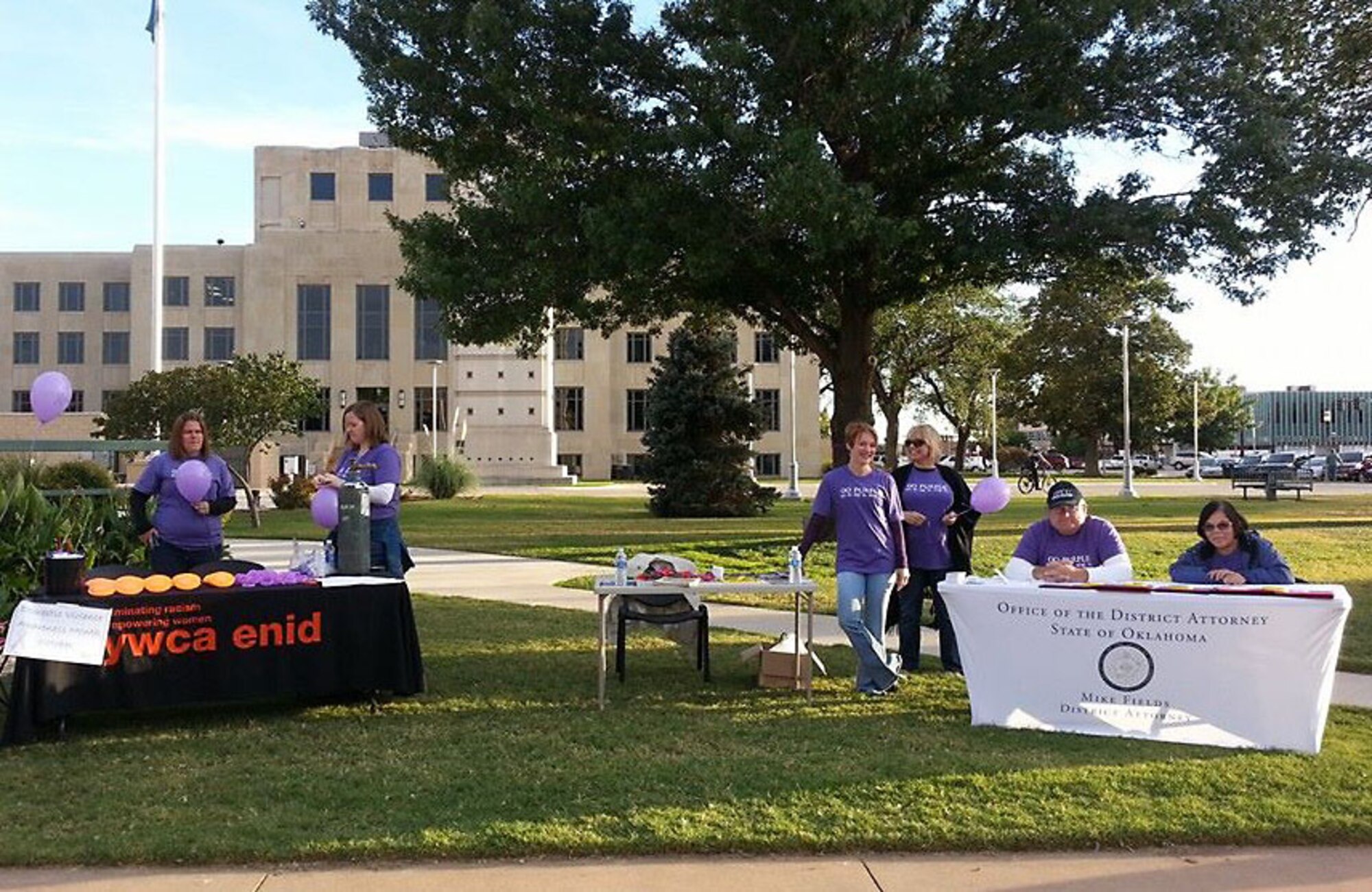 Representatives from the Enid, Young Women’s Christian Association, the Vance 71st Mental Health Element and the State District Attorney’s Office stand behind their information tables during Enid, Oklahoma’s First Friday celebration downtown Oct. 3. The Vance mental health staff were there to help educate the local community about preventing domestic violence during October, domestic violence awareness month. (Courtesy photo)