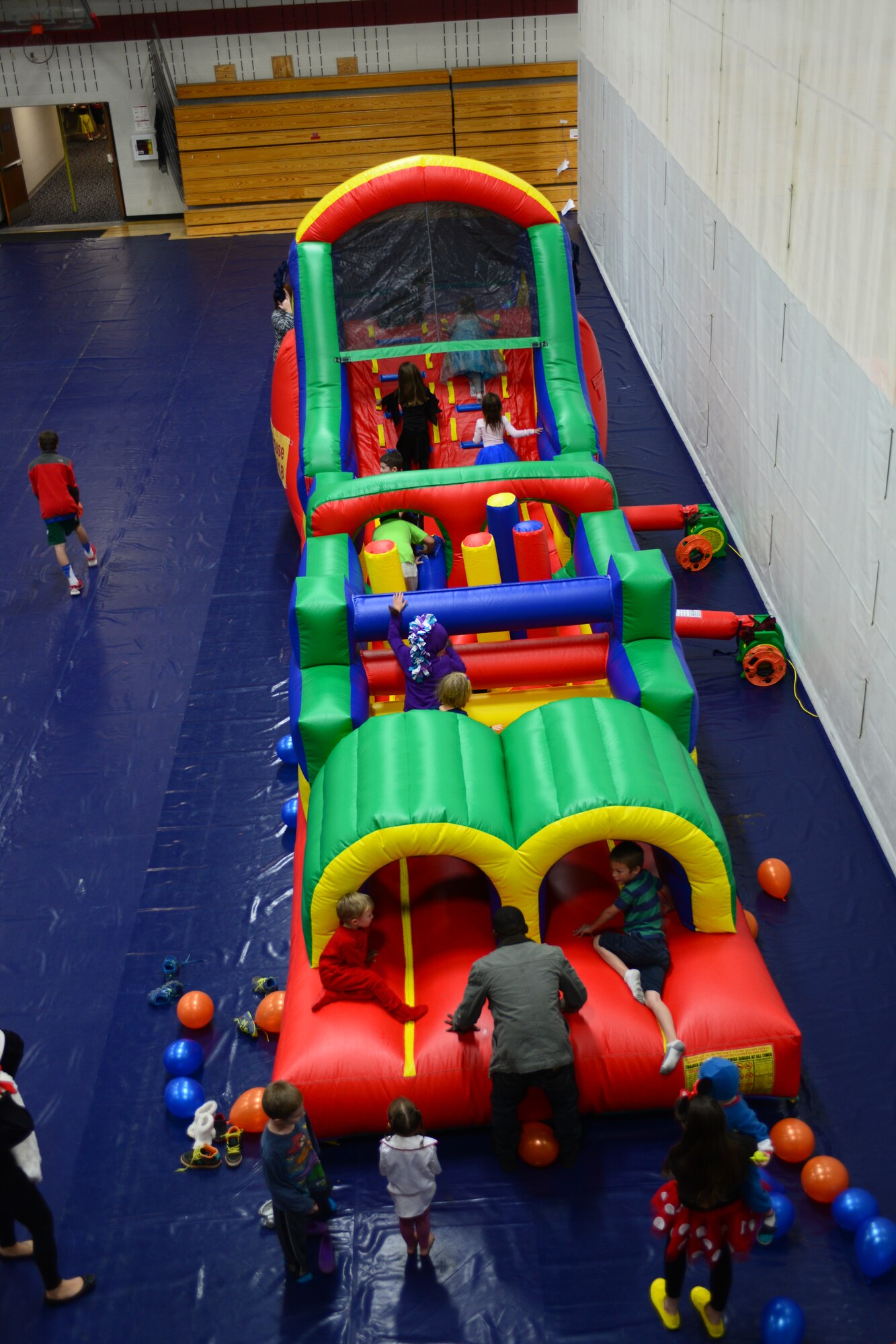 Children play on an inflatable attraction during the Halloween Kids Carnival event in the Bellamy Fitness Center at Ellsworth Air Force Base, S.D., Oct. 25, 2014. The event featured a  variety of activities for Airmen and families to enjoy such as face painting, music, free food, prizes and costume contests. (U.S. Air Force photo by Senior Airman Zachary Hada/Released)