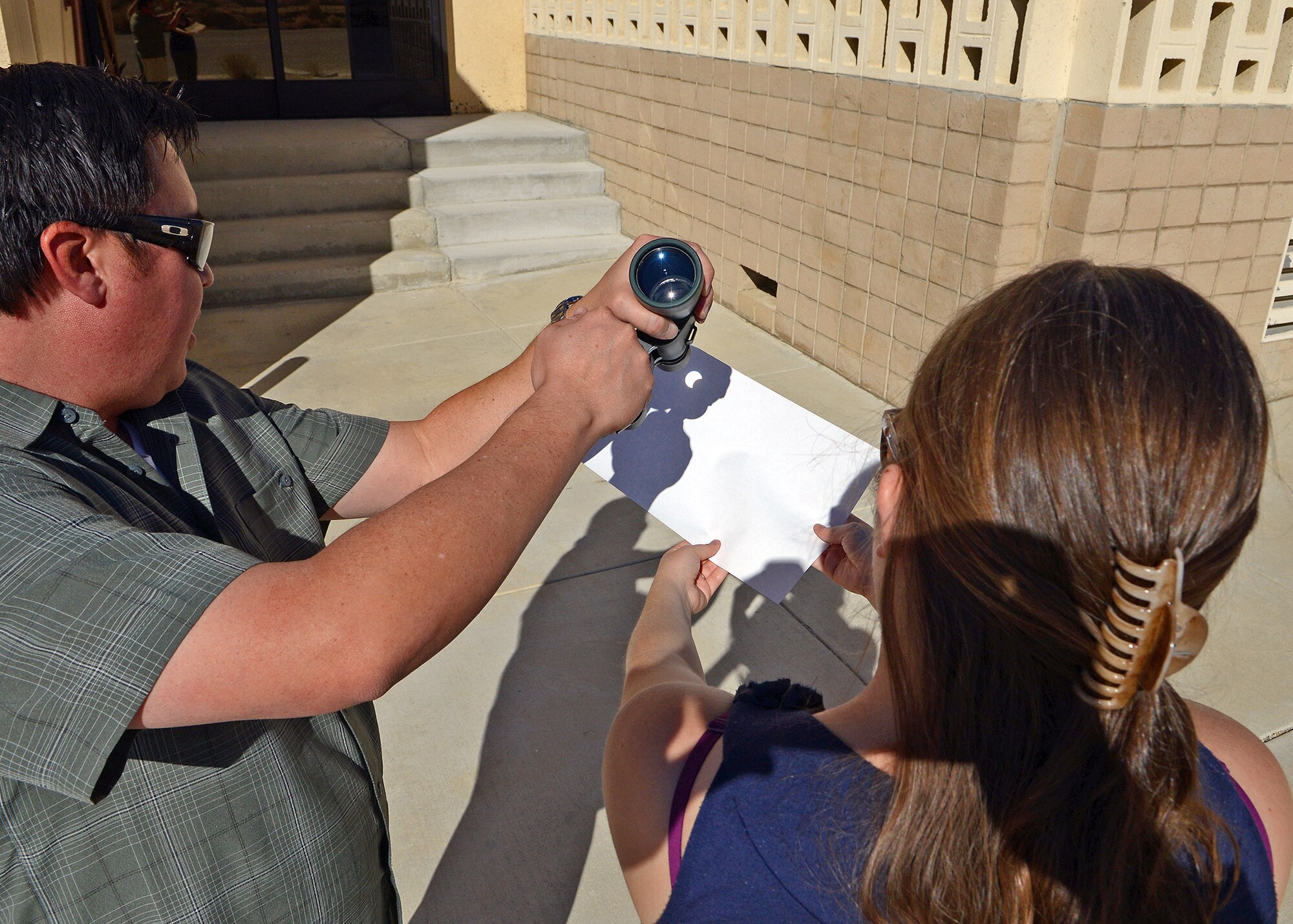 Members from 412th Test Wing Public Affairs office adjust assemble a projector using binoculars in order to view the partial solar eclipse that occurred Oct. 23. Partial solar eclipses happen when the Moon passes between the Sun and the Earth. EDITOR’S NOTE and WARNING: Never stare directly at the sun through binoculars. (U.S. Air Force photo by Jet Fabara)