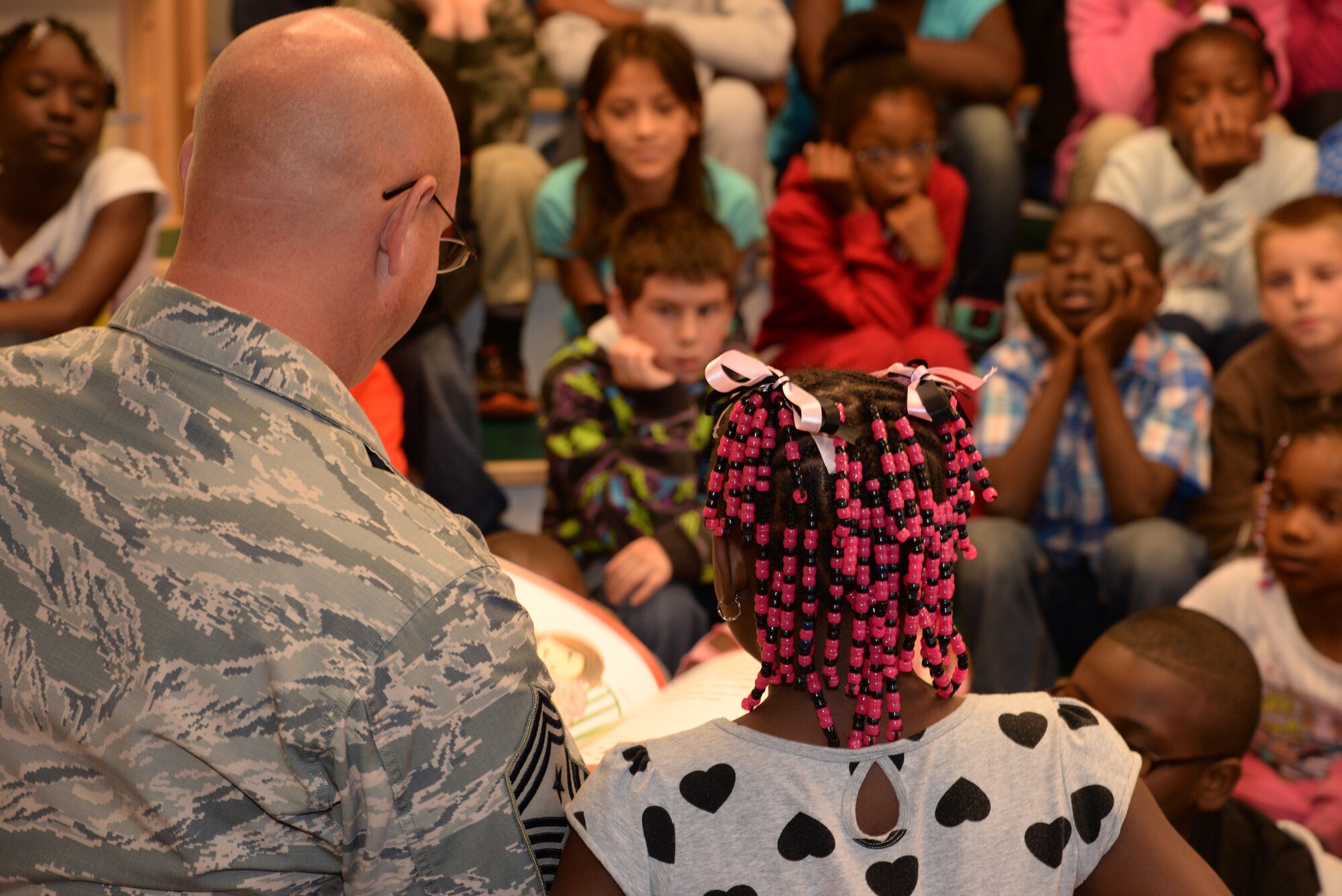 U.S. Air Force Chief Master Sgt. Scott Fuller, Ninth Air Force command chief, reads to a group of third grade students at F.J. DeLaine Elementary School, Sumter, S.C., Oct. 20, 2014. Ninth Air Force leadership spent several days going to different schools in the Sumter area and reading to students. (U.S. Air Force photo by Airman 1st Class Jonathan Bass/Released)