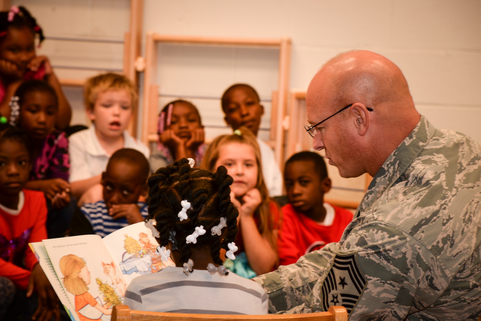 U.S. Air Force Chief Master Sgt. Scott Fuller, Ninth Air Force command chief, reads to a group of first grade students at F.J. DeLaine Elementary School, Sumter, S.C., Oct. 20, 2014. Fuller spent two hours reading to the students in an effort to teach children the importance of reading. (U.S. Air Force photo by Airman 1st Class Jonathan Bass/Released)