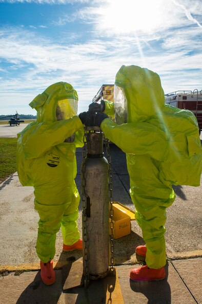 U.S. Air Force Senior Airman Benjamin Jacobson, left, 23d Civil Engineer Squadron operator and Ryan Miller, 23d CES firefighter, secure a simulated leaking chlorine cylinder Oct. 29, 2014, at Moody Air Force Base, Ga. Jacobson and Miller wore hazardous material level A suits, which prevent contamination while they secure hazardous material spills.  (U.S. Air Force photo by Airman 1st Class Ceaira Tinsley/Released)