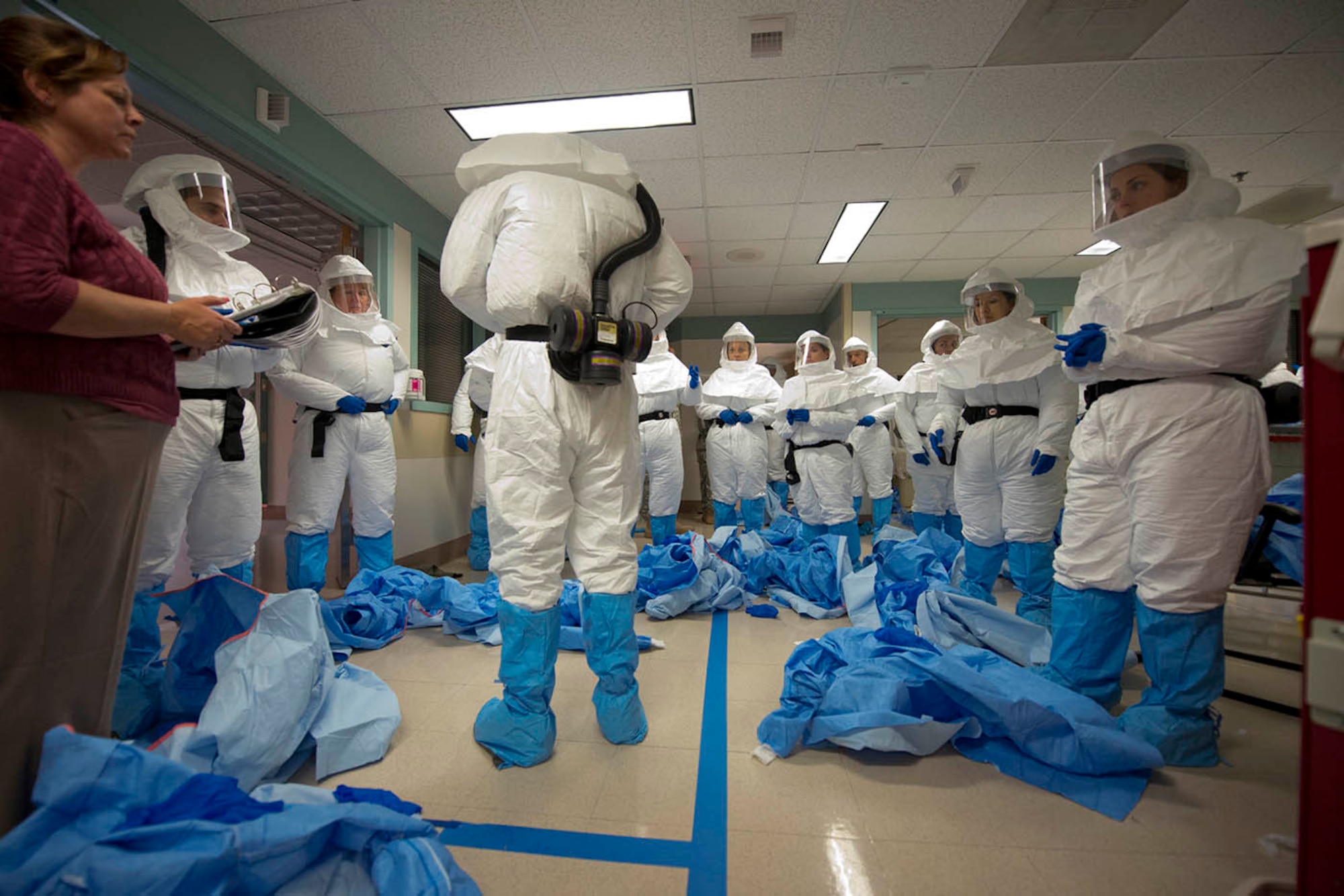 Members of the Ebola medical support team practice donning personal protective equipment during week-long training at the San Antonio Military Medical Center. The training prepares them to assist civilian medical professionals in the United States. Half of the medical personnel are from the Army, six are from the Air Force and nine from the Navy. The trainers came from the U.S. Army Medical Research Institute of Infectious Diseases in Frederick, Maryland. (U.S. Air Force photo/Master Sgt. Jeffrey Allen)