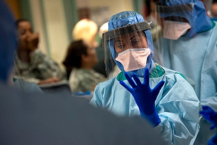 Air Force Capt. Stacey Morgan dons protective gloves during infection prevention and control training at the San Antonio Military Medical Center. Morgan is part of a 30-member Ebola medical support team, which will assist civilian medical in case of domestic emergency. (U.S. Air Force photo/Master Sgt. Jeffrey Allen)