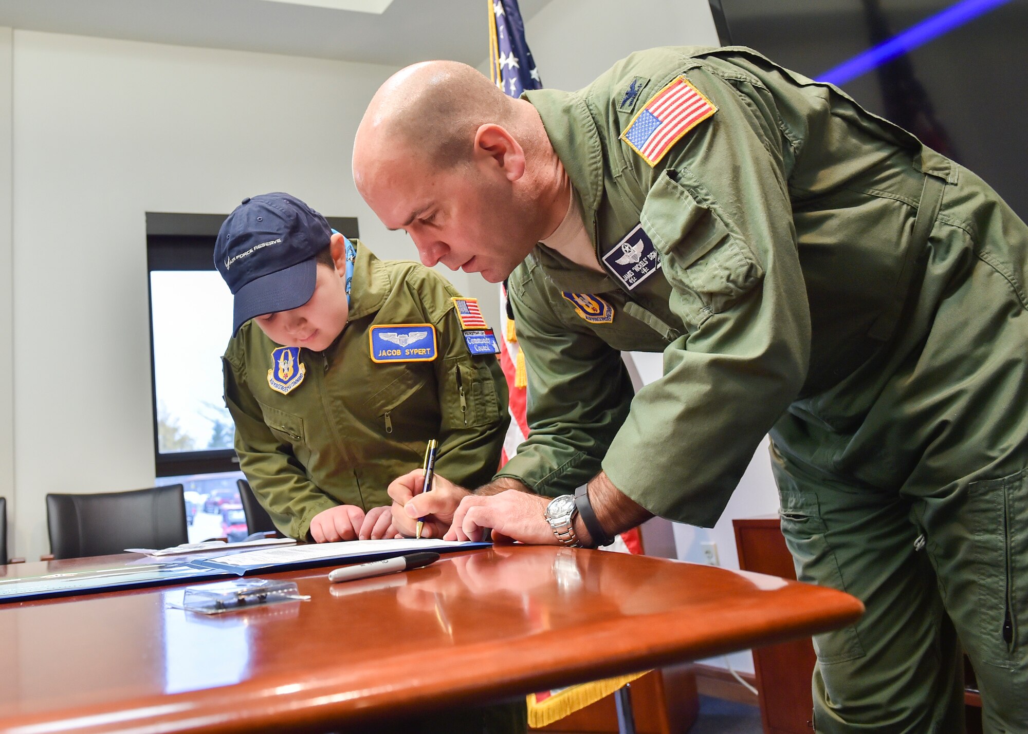 U.S. Air Force Reserve Col. James Dignan, 910th Airlift Wing commander, signs the oath of office with 11-year-old Jacob Sypert here, Oct. 29, 2014. Sypert became the 910th Airlift Wing’s 60th Pilot for a Day, being sworn in as an honorary second lieutenant and spending the day here experiencing military activities including a high-speed taxi down the runway in a Youngstown C-130H Hercules aircraft. The Pilot for a Day program began in 2000 as a community outreach event for the purpose of providing a fun-filled day for children with life-threatening or chronic illnesses. U.S. Air Force photo/Eric M. White