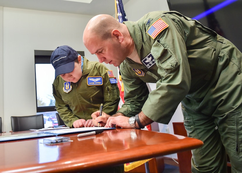 U.S. Air Force Reserve Col. James Dignan, 910th Airlift Wing commander, signs the oath of office with 11-year-old Jacob Sypert here, Oct. 29, 2014. Sypert became the 910th Airlift Wing’s 60th Pilot for a Day, being sworn in as an honorary second lieutenant and spending the day here experiencing military activities including a high-speed taxi down the runway in a Youngstown C-130H Hercules aircraft. The Pilot for a Day program began in 2000 as a community outreach event for the purpose of providing a fun-filled day for children with life-threatening or chronic illnesses. U.S. Air Force photo/Eric M. White