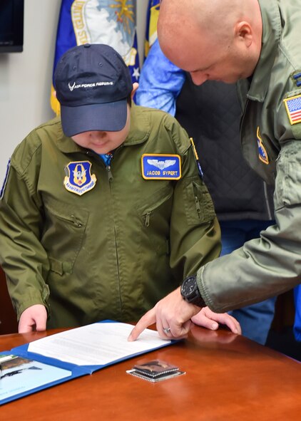 U.S. Air Force Reserve Capt. Brian Hodor, a Pilot with the 757th Airlift Squadron, shows the oath of office to 11-year-old Jacob Sypert here, Oct. 29, 2014. Sypert became the 910th Airlift Wing’s 60th Pilot for a Day, being sworn in as an honorary second lieutenant and spending the day here experiencing military activities including a high-speed taxi down the runway in a Youngstown C-130H Hercules aircraft. The Pilot for a Day program began in 2000 as a community outreach event for the purpose of providing a fun-filled day for children with life-threatening or chronic illnesses. U.S. Air Force photo/Eric M. White