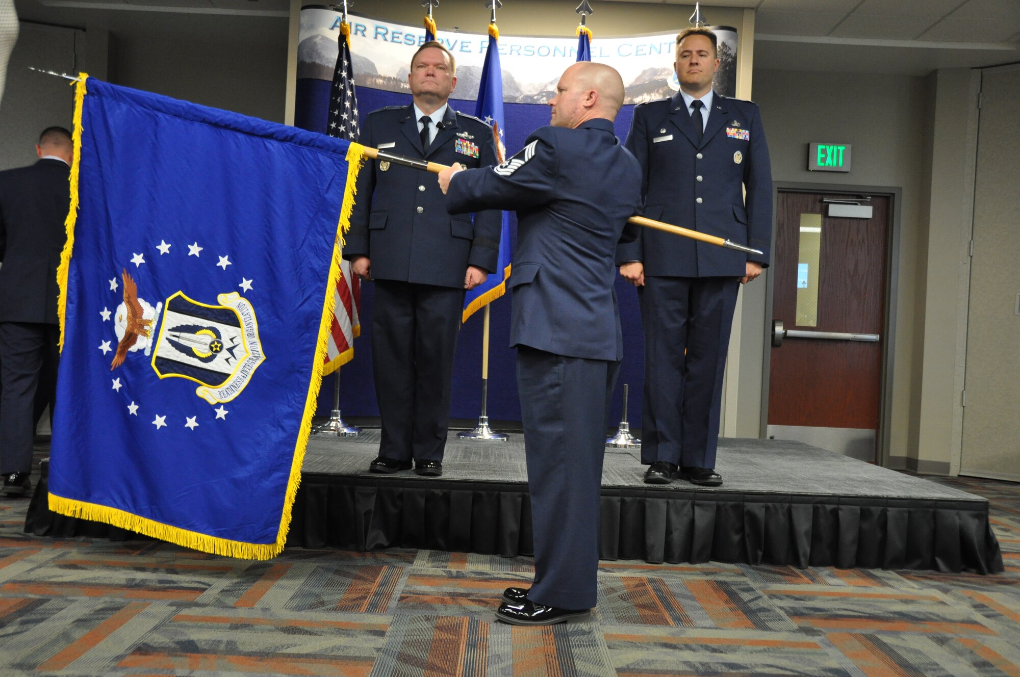 Chief Master Sgt. Seth Perron unfurls the new Headquarters RIO flag during a ceremonial activation, held Oct. 28 at Headquarters Air Reserve Personnel Center. The ceremony was presided over by Brig. Gen. Samuel C. Mahaney, ARPC commander, and Col. Christopher E. Cronce assumed command of the new organization. (U.S. Air Force photo/MSgt. Richard Grybos)