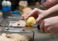 Airman 1st Class Amy Elliott, 436th Operations Support Squadron office administrator, grates lemon peel on raw chicken during a “Dorm to Gourm” Leadership Pathways Professional Development course Oct. 28, 2014, at the fitness center on Dover Air Force Base, Del. The course’s purpose was to teach Airmen, who live in the dorms, how to cook healthy meals for themselves. (U.S. Air Force photo/Airman 1st Class Zachary Cacicia)   