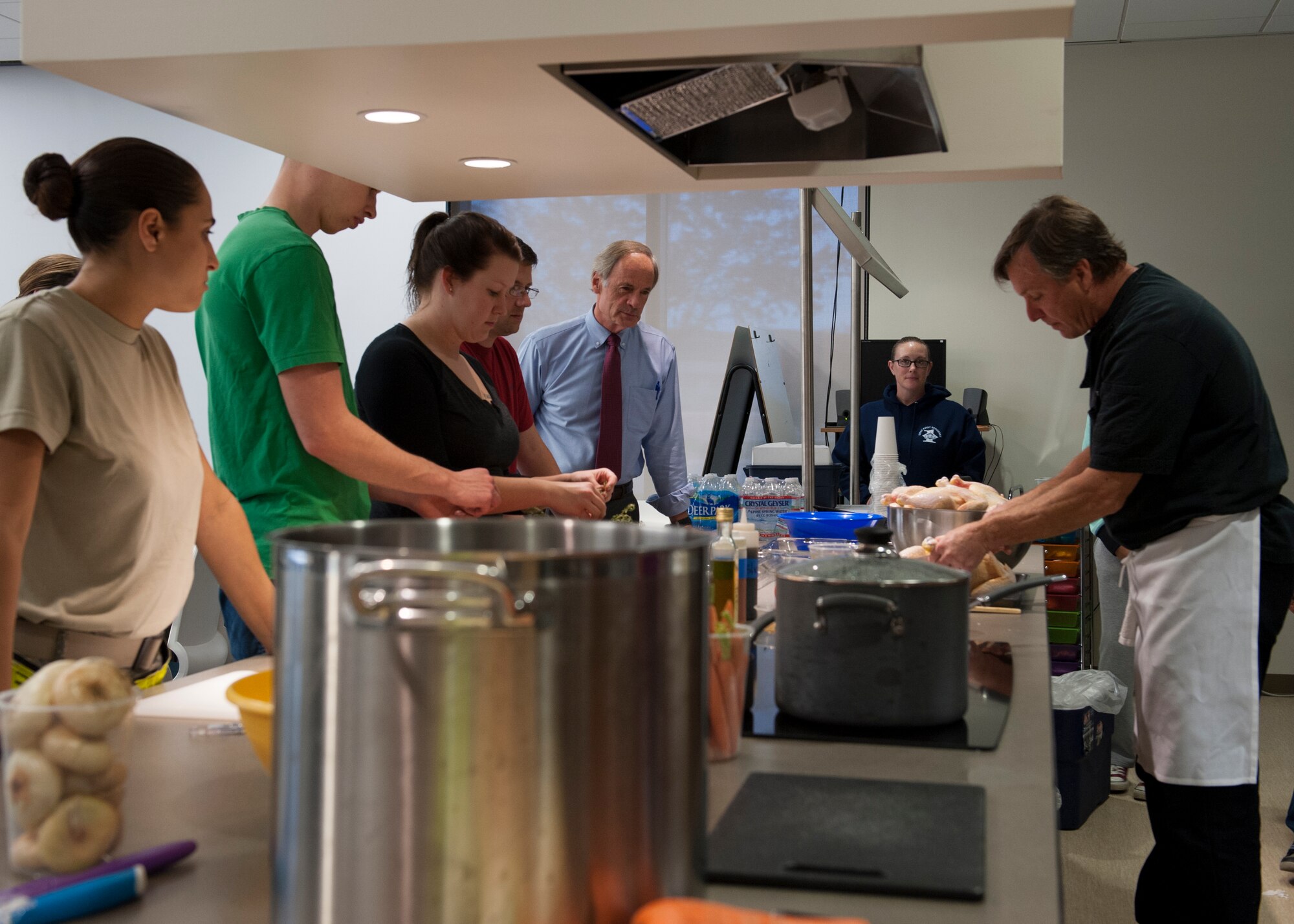 Team Dover Airmen and U.S. Sen. Tom Carper of Delaware, listen to cooking instructions from Kevin Reading, Abbott’s Grill chef and owner, during a “Dorm to Gourm” Leadership Pathways Professional Development course Oct. 28, 2014, at the fitness center on Dover Air Force Base, Del. Carper and Dover Mayor Robin Christiansen attended the event to show their support for Team Dover Airmen and Dover AFB’s mission. (U.S. Air Force photo/Airman 1st Class Zachary Cacicia)