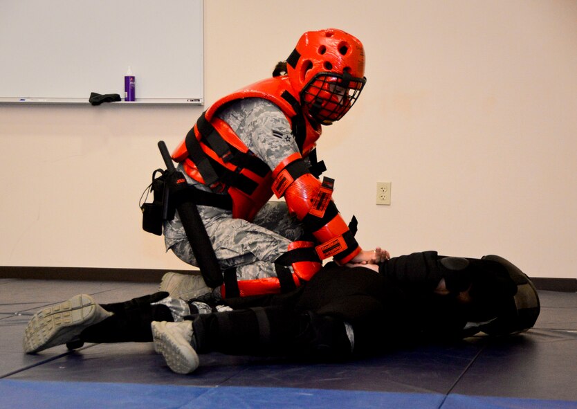 Airman 1st Class Emily Jacques, 2nd Security Forces Squadron installation entry controller, subdues a simulated suspect during an exercise on Barksdale Air Force Base, La., Oct. 27, 2014. As part of the exercise Airmen are evaluated on how to effectively approach a situation using the appropriate amount of force to subdue the subject. (U.S. Air Force photo/Airman 1st Class Mozer O. Da Cunha)