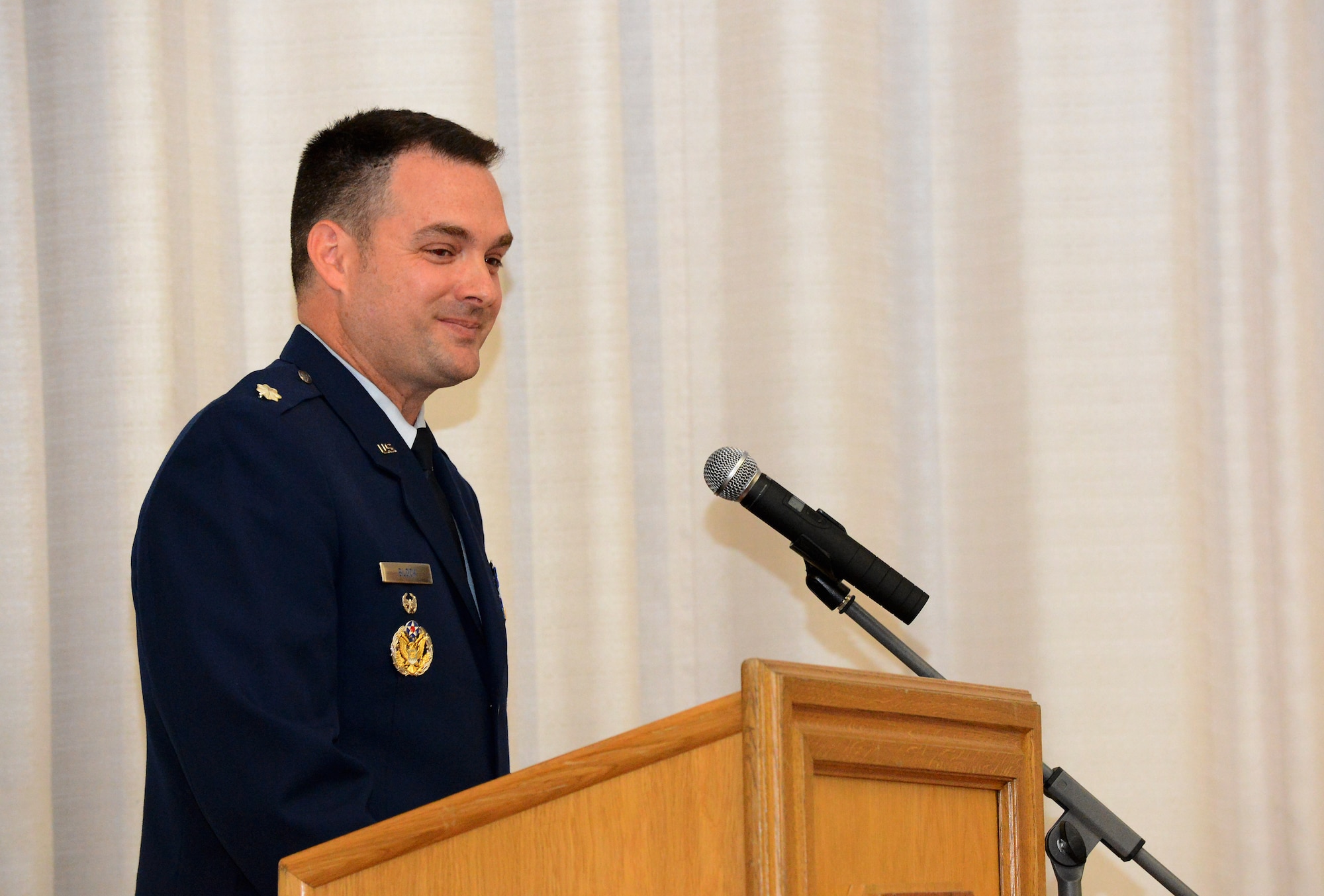 U.S. Air Force Lt. Col. Jay Block, 52nd Munitions Maintenance Group deputy commander, smiles during his speech to the Community College of the Air Force graduates at the base theater on Spangdahlem Air Base, Germany, Oct. 29, 2014. Block was the guest speaker at the ceremony. (U.S. Air Force photo by Airman 1st Class Luke Kitterman/Released)