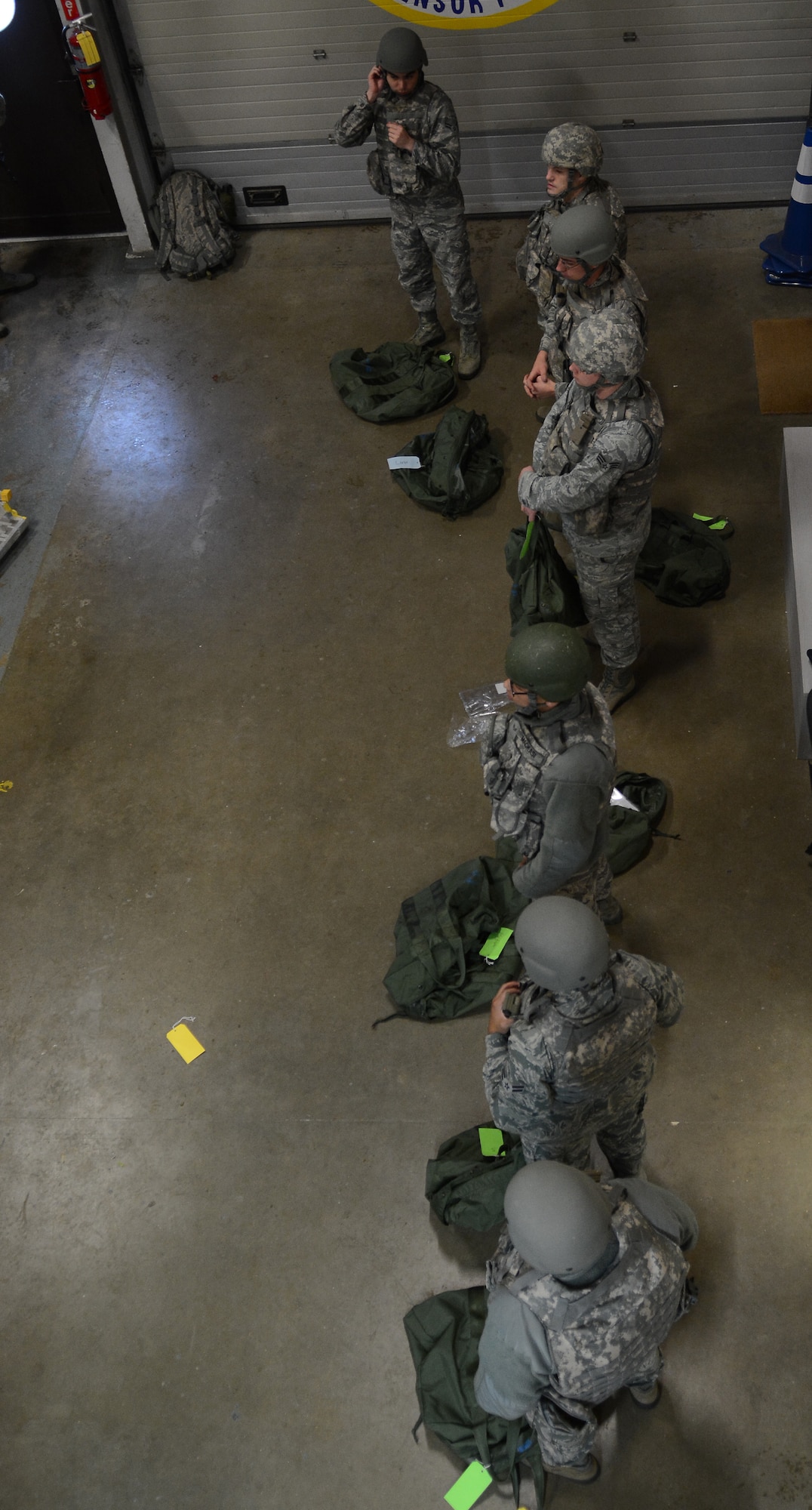 U.S. Air Force security forces augmentees wait for instructions after donning their gear during an exercise Oct. 8, 2014, on RAF Mildenhall, England. Augmentees were issued protective body armor and M16 assault rifles so they could perform basic military police duties. (U.S. Air Force photo by Staff Sgt. Micaiah Anthony/Released)