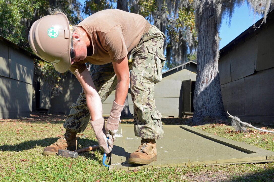 Navy Seaman Nikki Verdin removes trim from a door during renovations of Southeast Asian huts on Marine Corps Air Station New River, Jacksonville, N.C., Oct. 28, 2014. Verdin is a steelworker constructionman assigned to Naval Mobile Construction Battalion 1.  