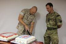 Maj. Gen. Richard L. Simcock, Commanding General, 2nd Marine Expeditionary Brigade (MEB), presents a cake to Maj. Will Clarke, future operations planner with the British Royal Marines, celebrating their 350th birthday on the USS Kearsarge (LHD3) at its home port, Naval Operations Base Norfolk, Va., during exercise Bold Alligator 14, Oct. 28, 2014. Bold Alligator is a multi-national, synthetic naval amphibious exercise designed to train the full range of amphibious capabilities in order to provide unique and contemporary solutions to global challenges.