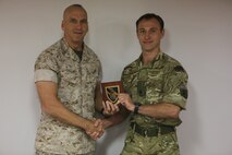 Maj. Will Clarke, future operations planner with the British Royal Marines, presents a plaque to Maj. Gen. Richard L. Simcock, Commanding General, 2nd Marine Expeditionary Brigade (MEB), on the USS Kearsarge (LHD3) at its home port, Naval Operations Base Norfolk, Va., during exercise Bold Alligator 14, Oct. 28, 2014. Bold Alligator is a multi-national, synthetic naval amphibious exercise designed to train the full range of amphibious capabilities in order to provide unique and contemporary solutions to global challenges.