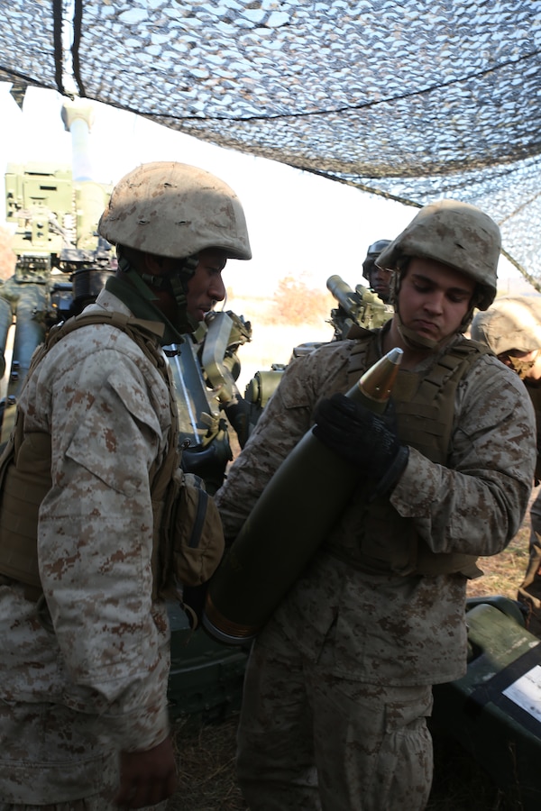 FORT INDIANTOWN GAP, Pa. - Lance Cpl. Wayne Rohall (Right) a field artilleryman with India Battery, 3rd Battalion 14th Marine Regiment, 4th Marine Division, inspects ammunition with section chief Sgt. Julian E. Gomez III, before loading a M777A2 Lightweight  Howitzer, Oct. 25, 2014 at Fort Indiantown Gap, Pa., during exercise Twisted Sister.  Exercise Twisted Sister was a live-fire artillery training exercise designed to hone tactics, techniques and procedures at the battalion level. (Marine Corps Photo by Cpl. J. Gage Karwick/Released)