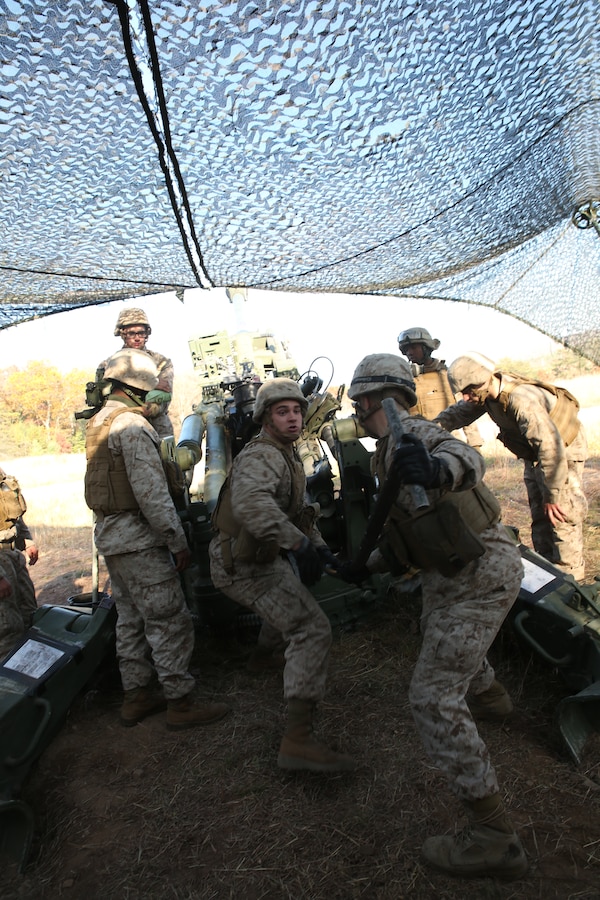 FORT INDIANTOWN GAP, Pa. - Lance Cpl. Wayne Rohall (middle) and Lance Cpl. Steven Foster, field artillerymen with India Battery, 3rd Battalion 14th Marine Regiment, 4th Marine Division, ram a round into a M777A2 Lightweight Howitzer, Oct. 25, 2014 at Fort Indiantown Gap, Pa., during exercise Twisted Sister.  Exercise Twisted Sister was a live-fire artillery training exercise designed to hone tactics, techniques and procedures at the battalion level. (Marine Corps Photo by Cpl. J. Gage Karwick/Released)