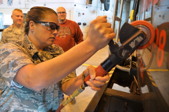Col. Linda Hurry grinds off a JP-8 fuel decal on an R11 refueler as part of the Air Force transition to commercial jet fuel Oct. 15, 2014, Scott Air Force Base, Ill. The Jet A conversion is a Department of Defense cost saving initiative that will save the Air Force approximately $25.5 million dollars annually. Hurry is the 635th Supply Chain Operations Wing Commander. (U.S. Air Force photo/Tech Sgt. Christopher Boitz)