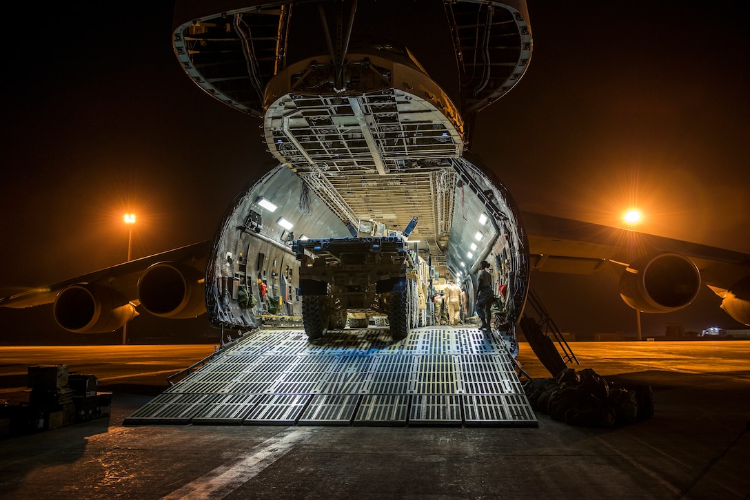 Airmen from the 9th Airlift Squadron and 455th Expeditionary Aerial Port Squadron with Marines from the Marine Expeditionary Brigade load vehicles into a C-5M Super Galaxy Oct. 6, 2014, at Camp Bastion, Afghanistan. Airmen and Marines loaded more than 266,000 pounds of cargo onto the C-5M as part of retrograde operations in Afghanistan. During this mission, the crew reached more than 11 million pounds of cargo transported in a 50-day period. (U.S. Air Force photo/Staff Sgt. Jeremy Bowcock)