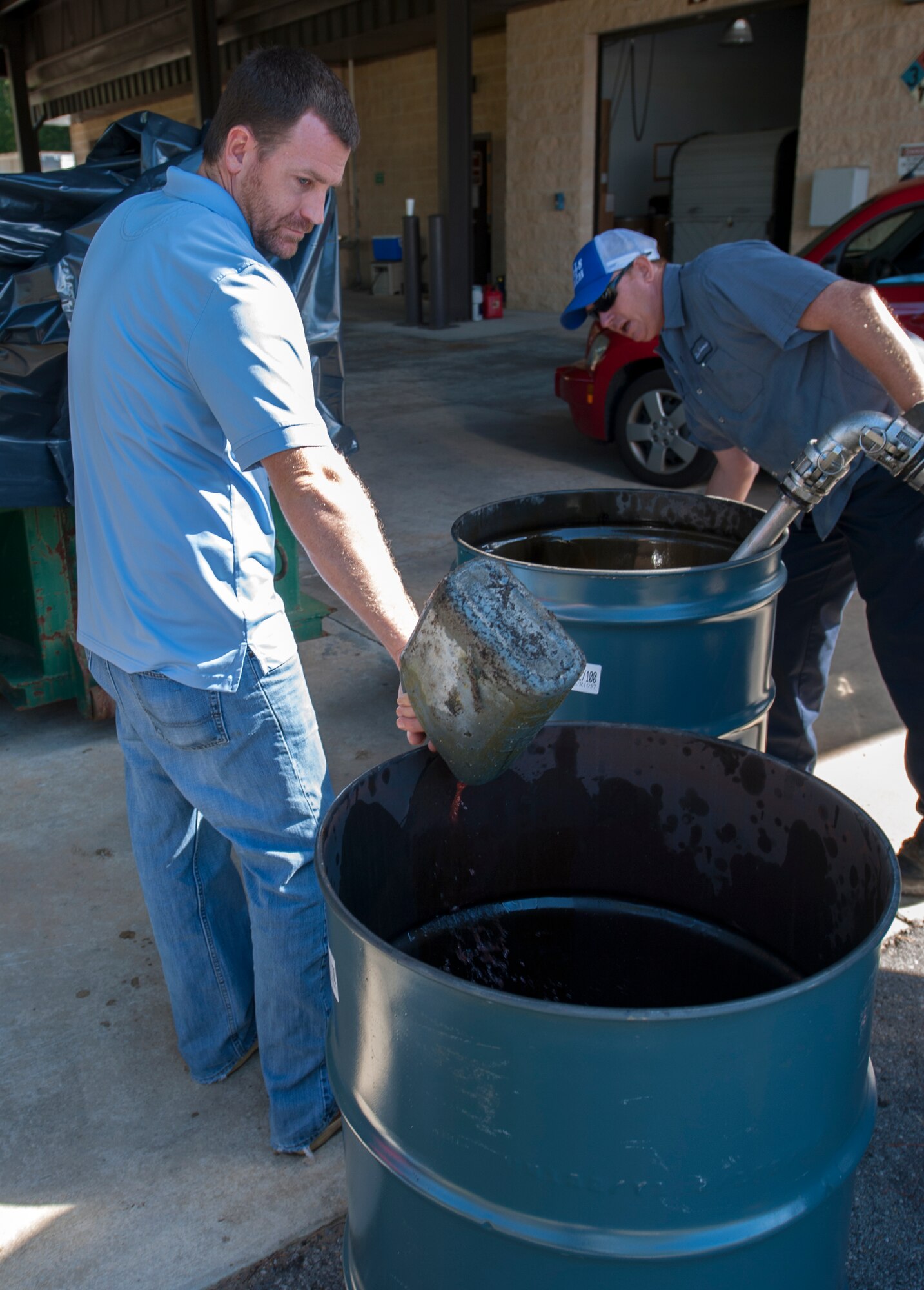 Jonathon Colmer, Hurlburt Field 90-Day Hazardous Waste Collection Facility supervisor, pours used oil into a drum during a Household Hazardous Waste Collection Day at Hurlburt Field, Fla., Oct. 24, 2014. The fluids were transported to a nearby plant to be recycled into reusable fuel. (U.S. Air Force photo/Senior Airman Kentavist P. Brackin)