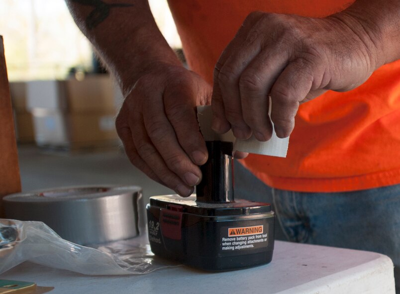 An Okaloosa County Hazardous Waste worker tapes off a battery terminal during a Household Hazardous Waste Collection Day at Hurlburt Field, Fla., Oct. 24, 2014. The terminals are taped to prevent fluid from leaking, which can potentially cause a chemical fire. (U.S. Air Force photo/Senior Airman Kentavist P. Brackin)