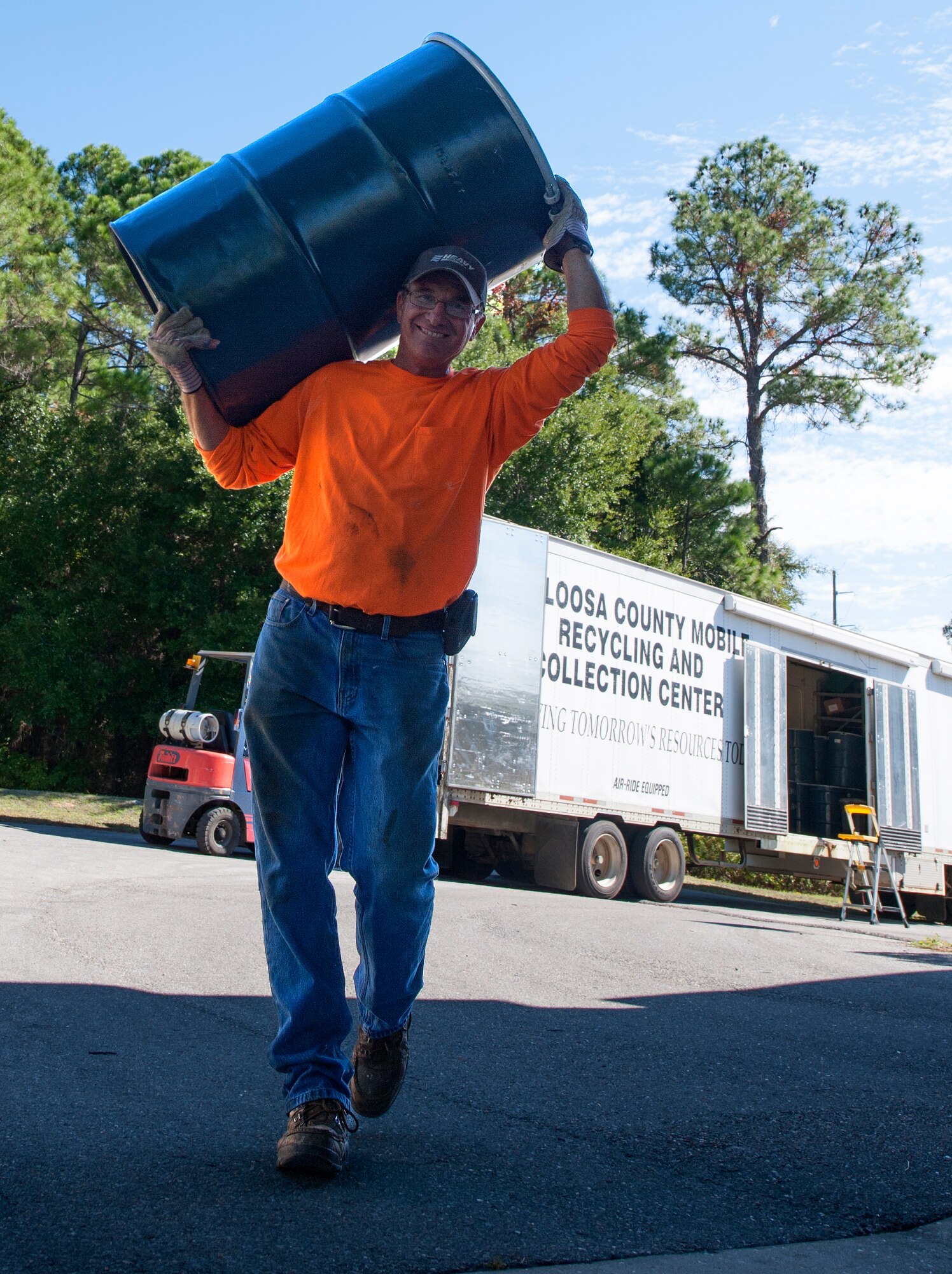 Darryl Roper, Okaloosa County Hazardous Waste recycling foreman, carries a 50-gallon drum during a Household Hazardous Waste Collection Day at Hurlburt Field, Fla., Oct. 24, 2014. The drums were used to collect items such as batteries, oil and paint. (U.S. Air Force photo/Senior Airman Kentavist P. Brackin)